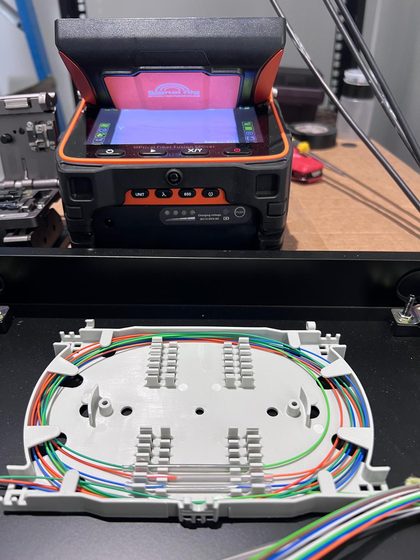 Splice tray with neatly routed color fibers next to the fusion splicer