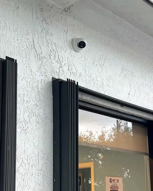 Cámara de seguridad domo instalada en la fachada de una clínica