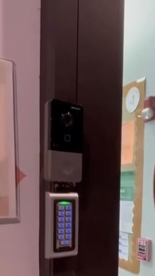 Lector de control de acceso con teclado y timbre con cámara en la entrada de un daycare