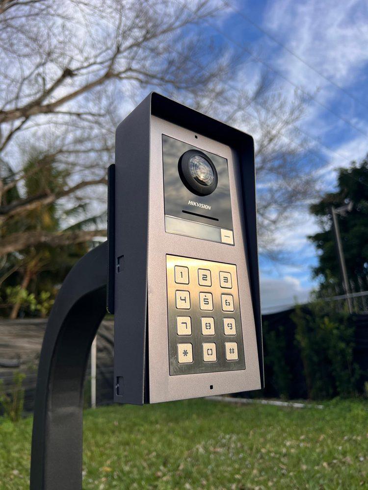 Hikvision intercom with camera and keypad on a gate post