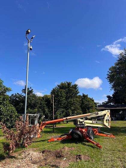 Cámara PTZ instalada en un poste alto con reflectores en una finca, con plataforma elevadora