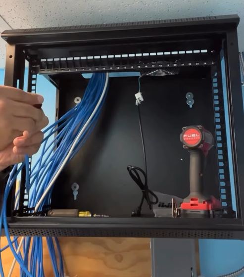 Técnico de HT Tech organizando el cableado Cat6 dentro del rack