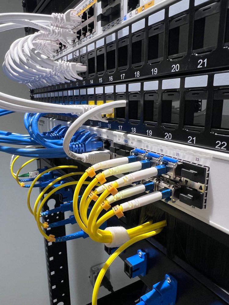 Labeled fiber optic patch cords connected to a switch in the rack