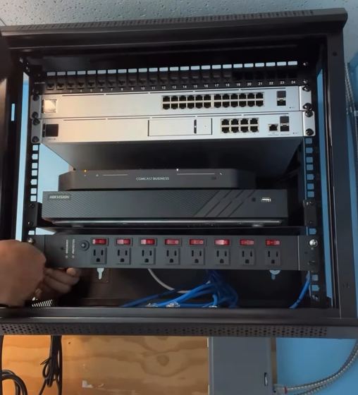 Rack de red terminado en una clínica médica: switches, grabador de cámaras y regleta