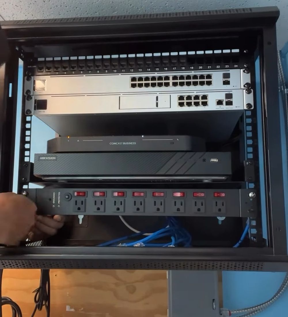 Rack de red terminado en una clínica médica: switches, grabador de cámaras y regleta