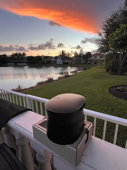 Sonos speaker on a lakeside terrace at sunset