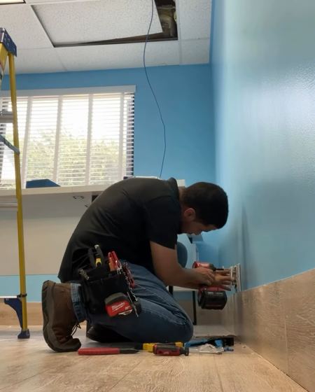 Técnico de HT Tech instalando puntos de red en una clínica