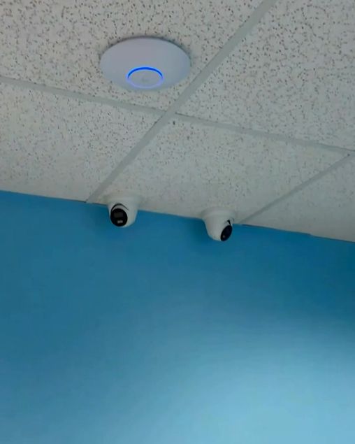 Wi-Fi access point and dome cameras installed on a clinic ceiling
